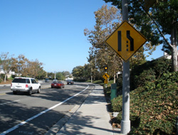 Lanes merging sign on the side of a street